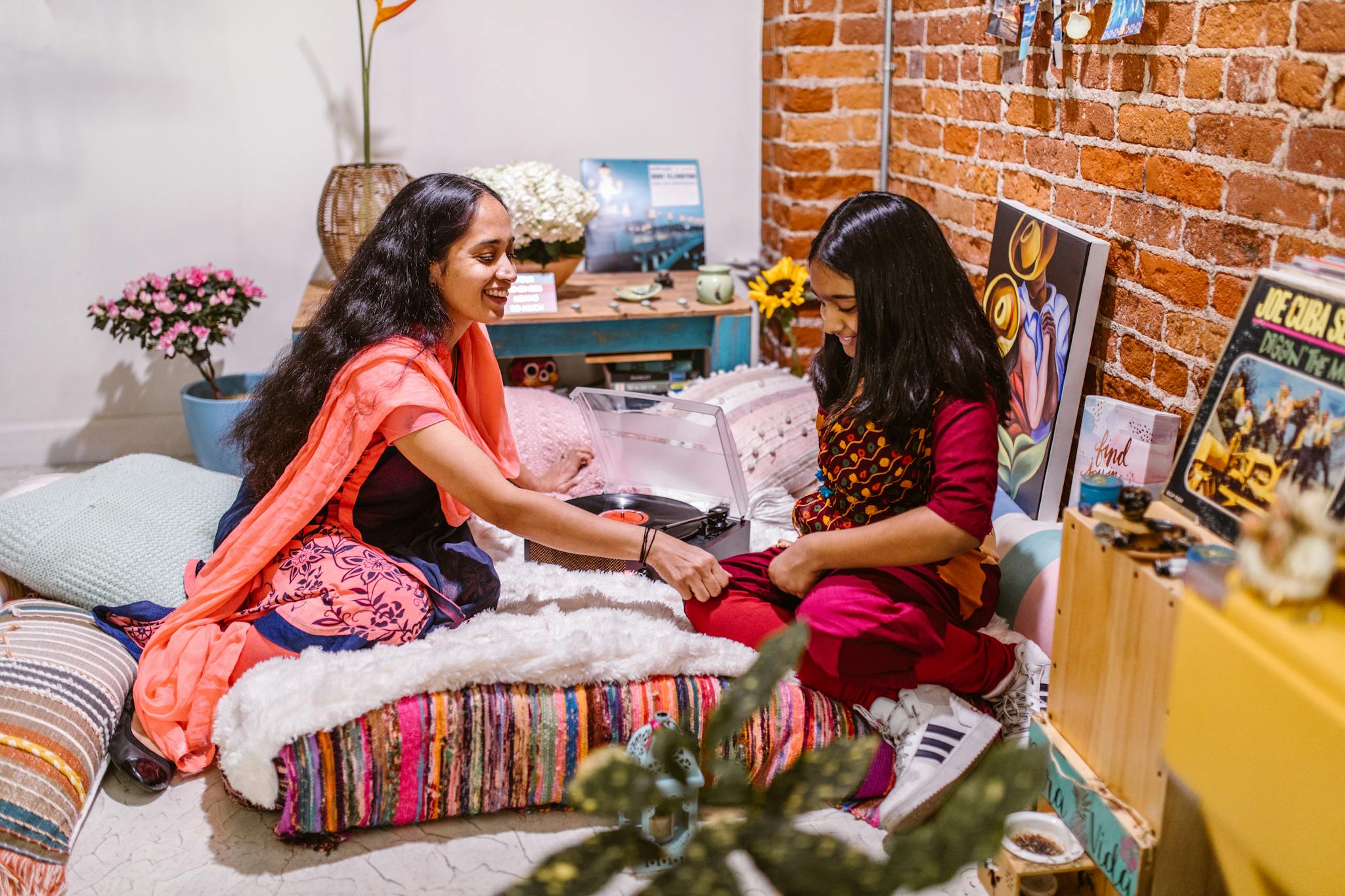 A joyful mother and daughter creating art together indoors, promoting quality family time.
