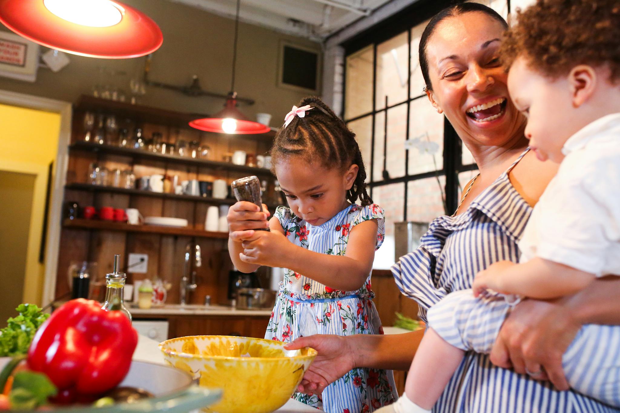 Mom and kids enjoy preparing food together in a cozy home kitchen.